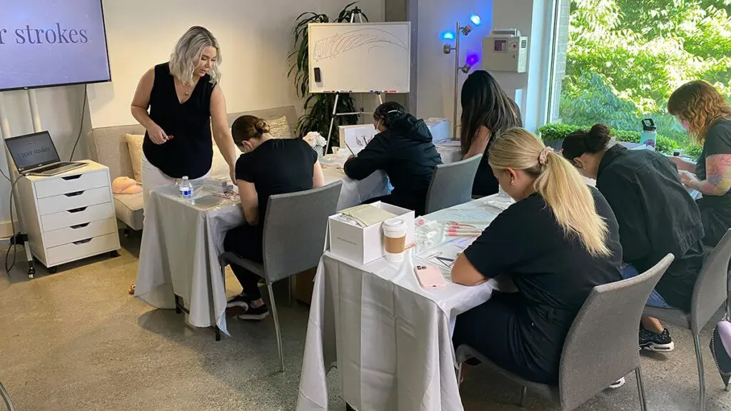 Permanent makeup students learning in a hands-on Beauty Angels Academy classroom