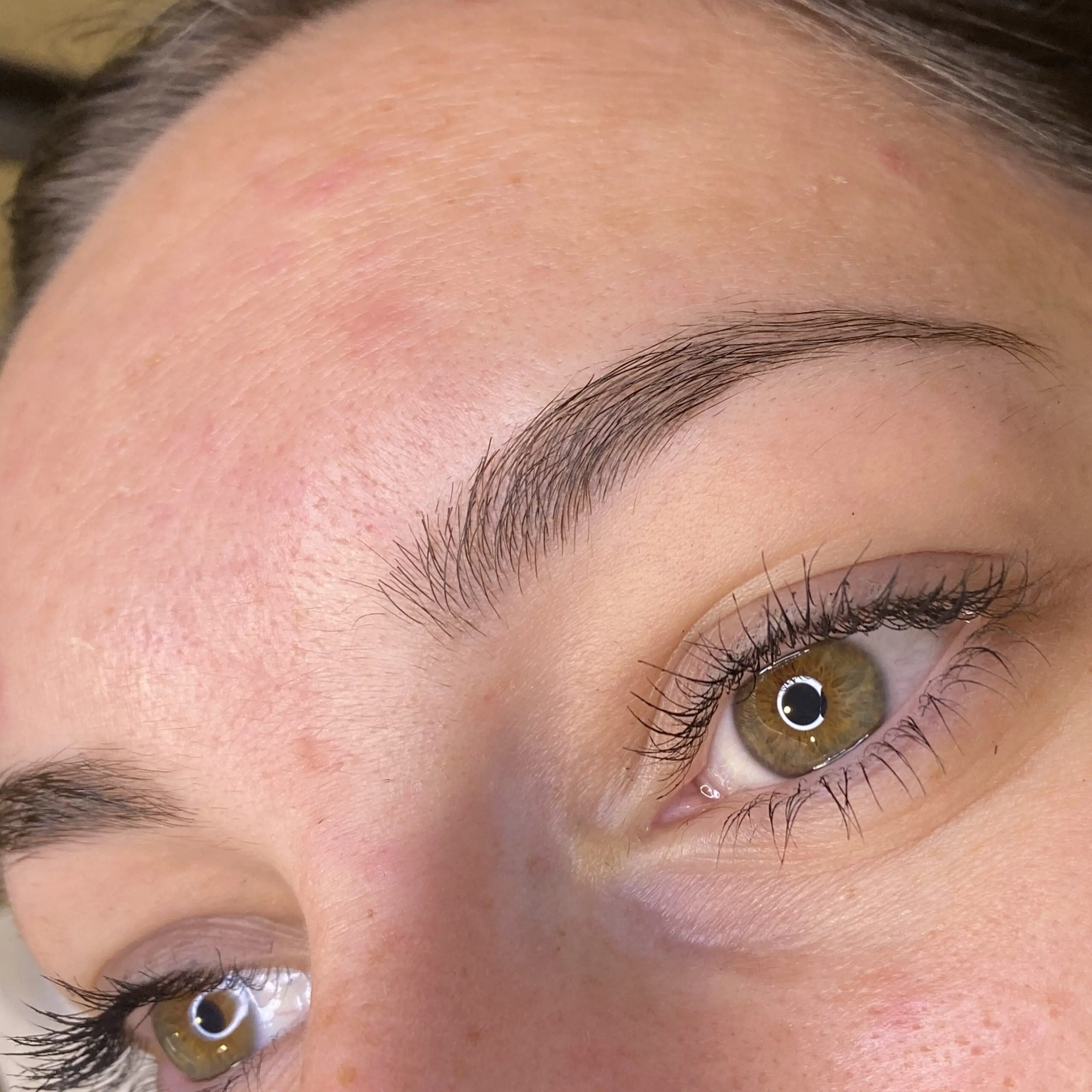 Close view of a client's permanent makeup brows and eyeliner
