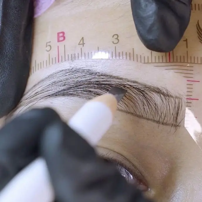 Permanent makeup brow mapping with a measuring tool