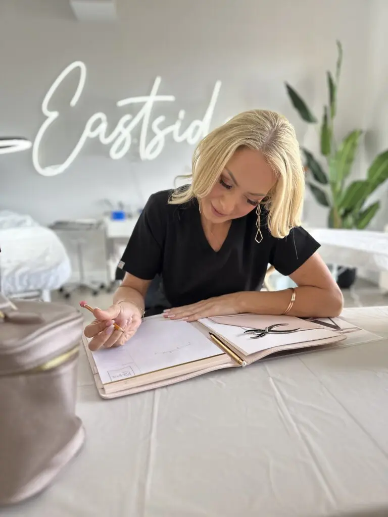 Permanent makeup instructor reviewing course materials at the Eastside studio